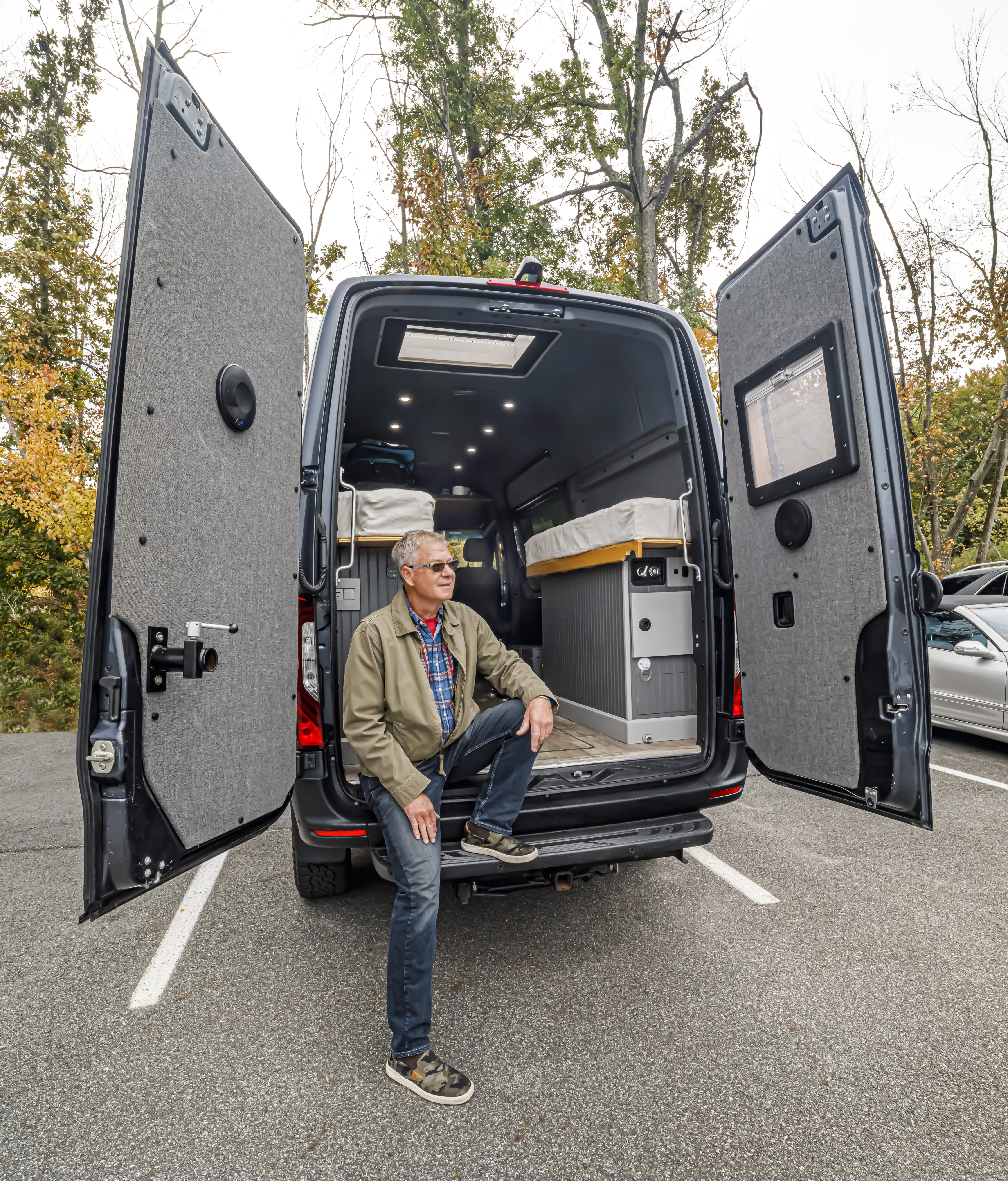 A Benzel-Busch customer sitting in the back of their custom Mercedes-Benz Sprinter featured for van life